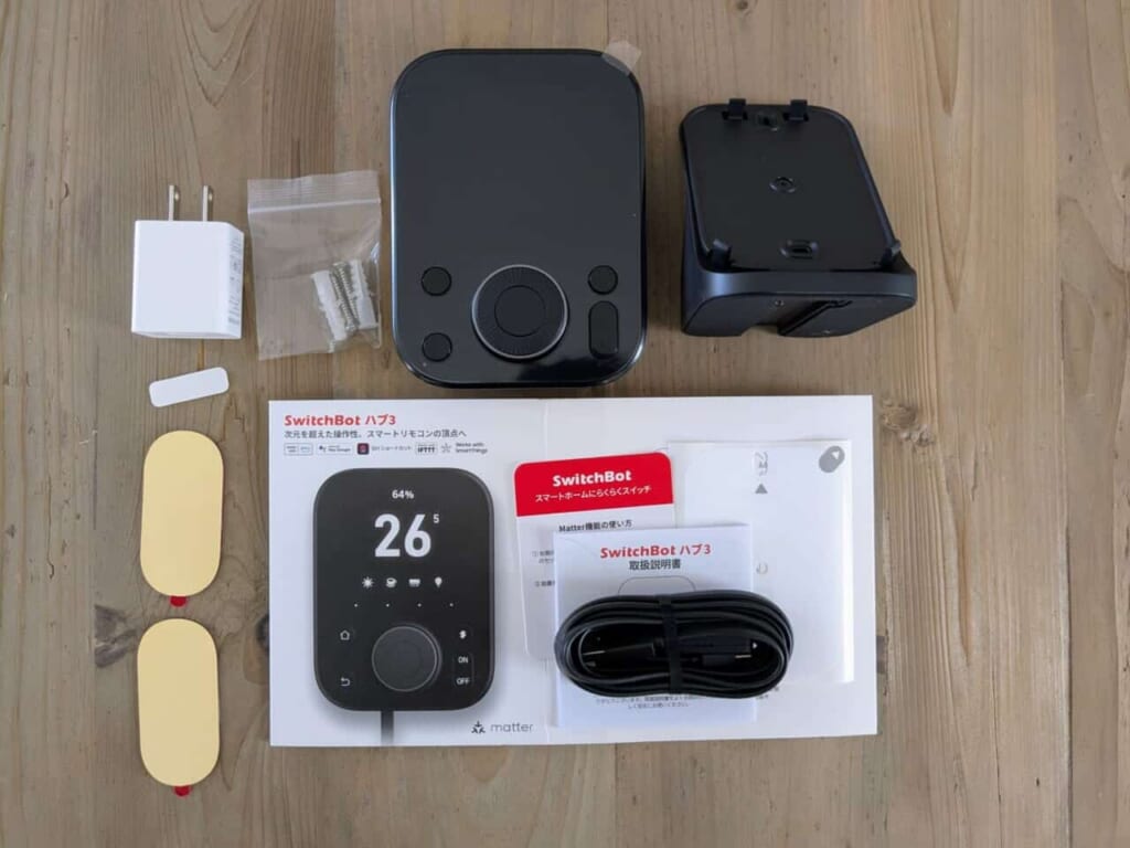 木目調のテーブル上に並べられた、SwitchBot ハブ3の製品パッケージ一式。